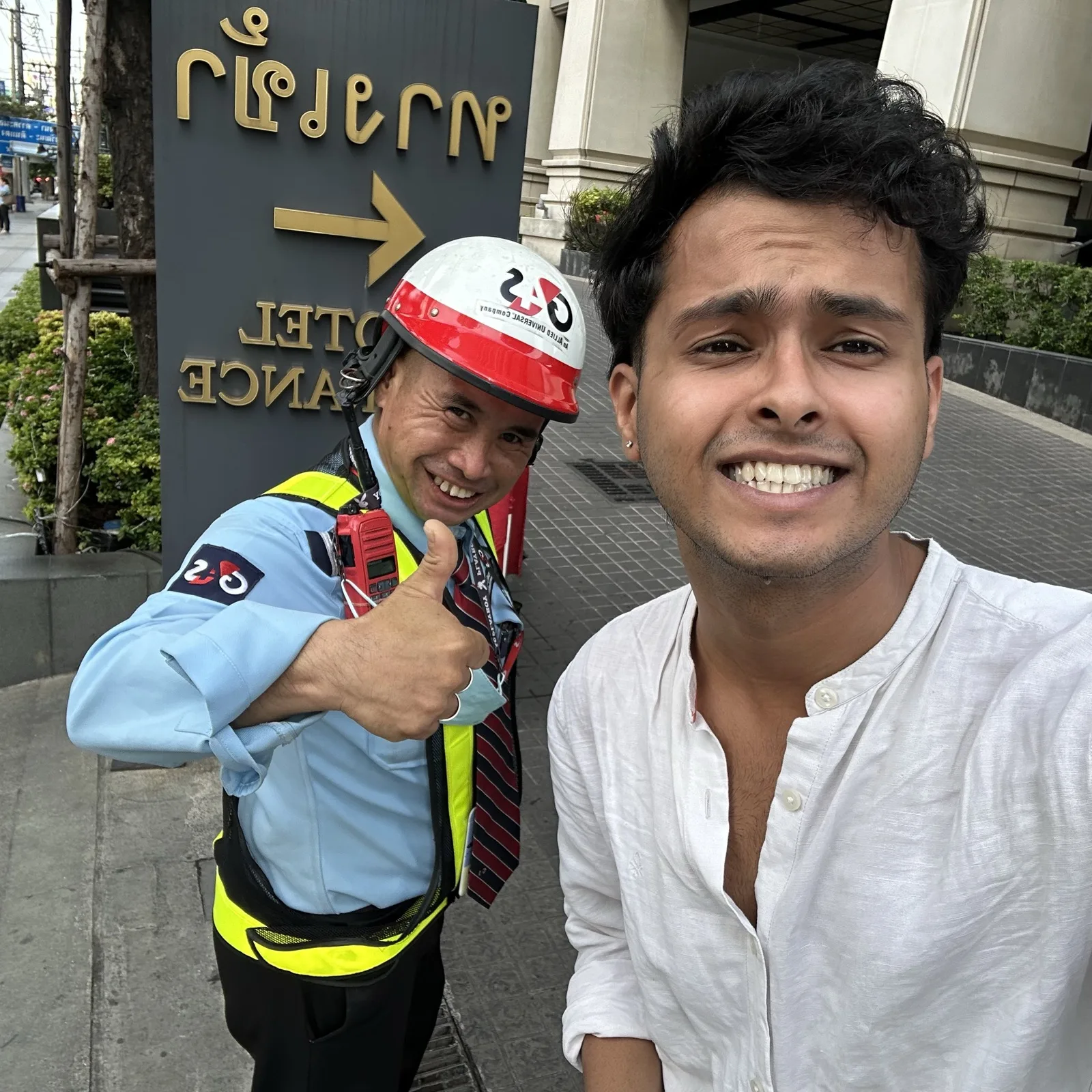 The smiling Lancaster hotel doorman in hi-vis giving a thumbs up in a selfie with Anish from the COR team